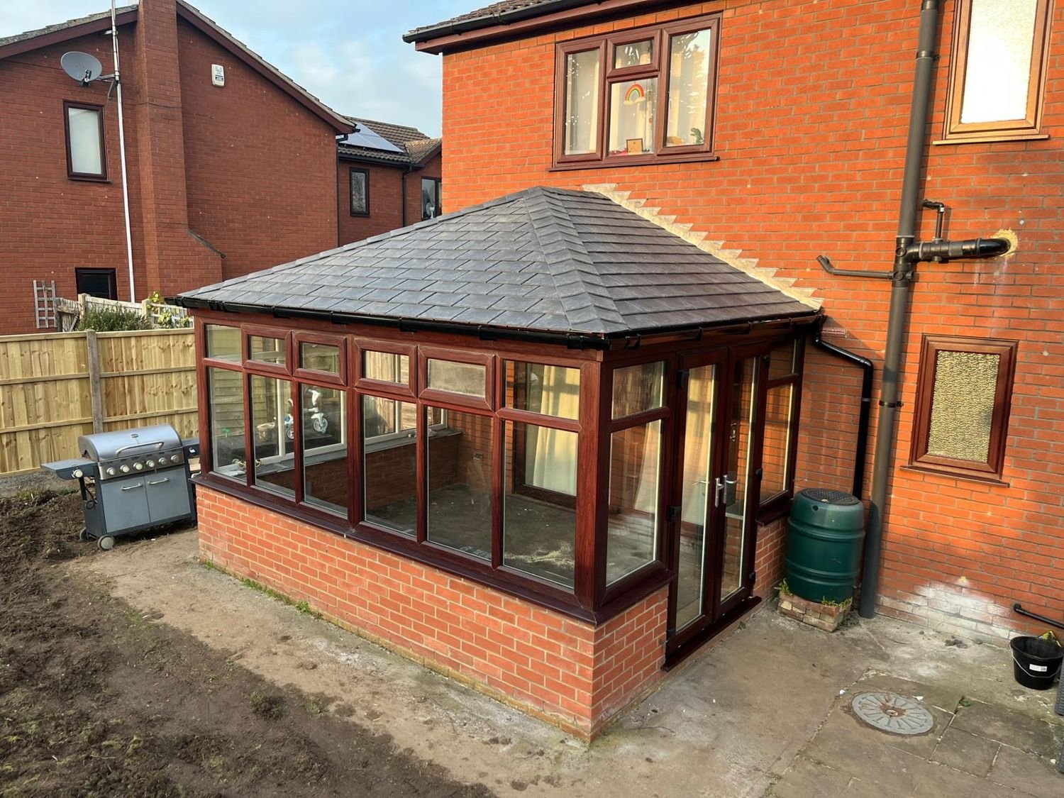 After: mahogany-framed conservatory, glass roof replaced by a tiled roof